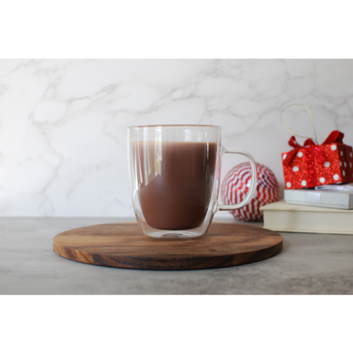 Metabolic Web Store MRC Creamy Hot Chocolate Protein Drink in a clear mug with holiday presents in the background